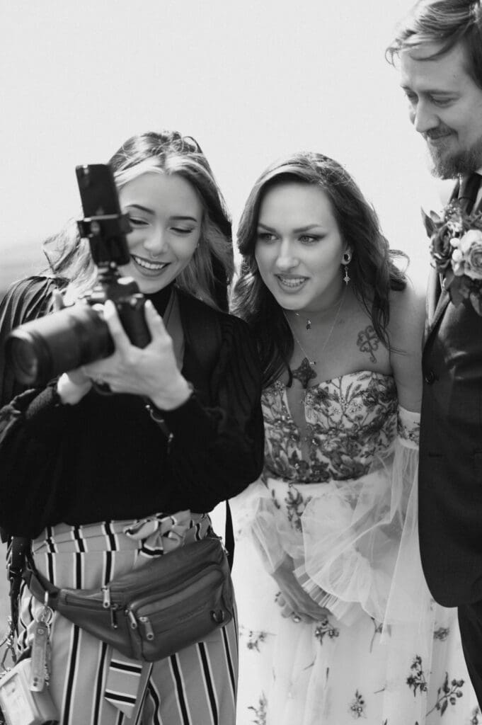Photographer showing a bride and groom the wedding photo she just captured during their Iowa wedding