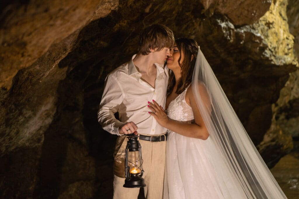 Eloping couple holding a lantern at Maquoketa Caves State Park in Iowa during an intimate outdoor ceremony